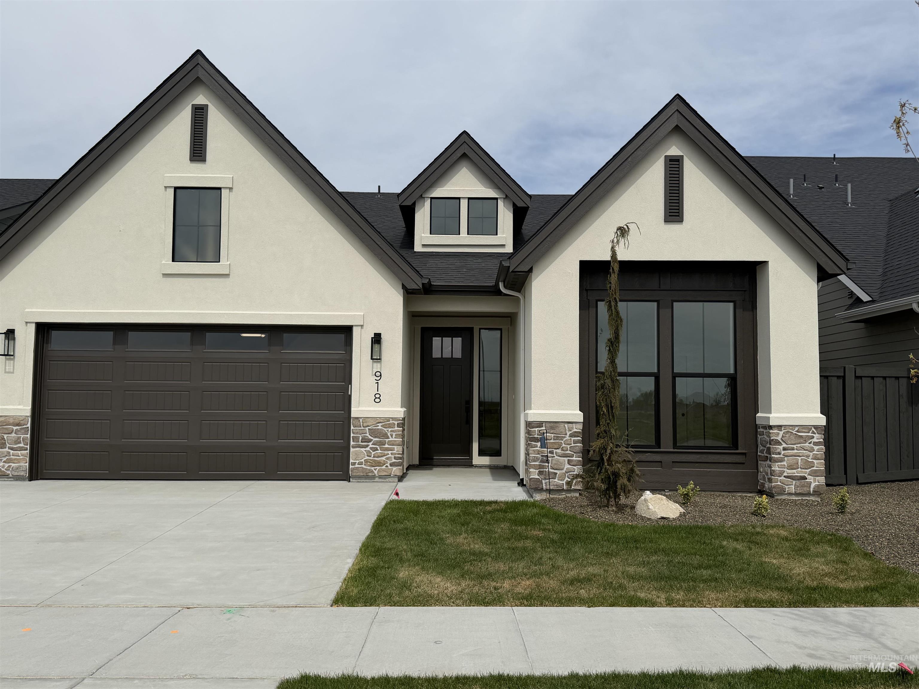 918 East Escalation Street Meridian, ID 83642 - Photo 30 of 30 View of front of house with stone siding, stucco siding, and concrete driveway