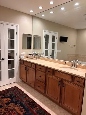 a bathroom with a double vanity sink and a large mirror