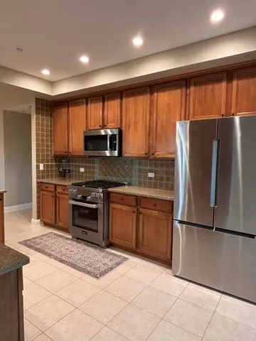 a kitchen with stainless steel appliances granite countertop a refrigerator stove and sink