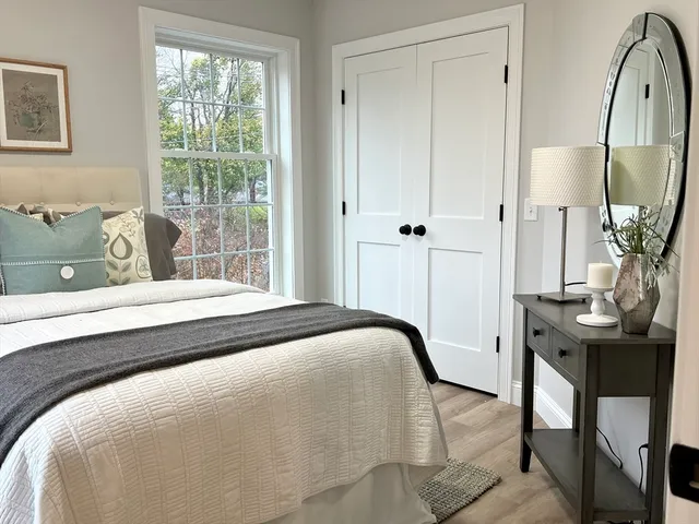 a bedroom with a bed a table and painting on the wall