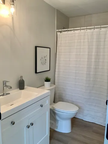 a bathroom with a white sink a toilet and a mirror