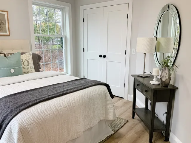 a bedroom with a bed a table and a mirror