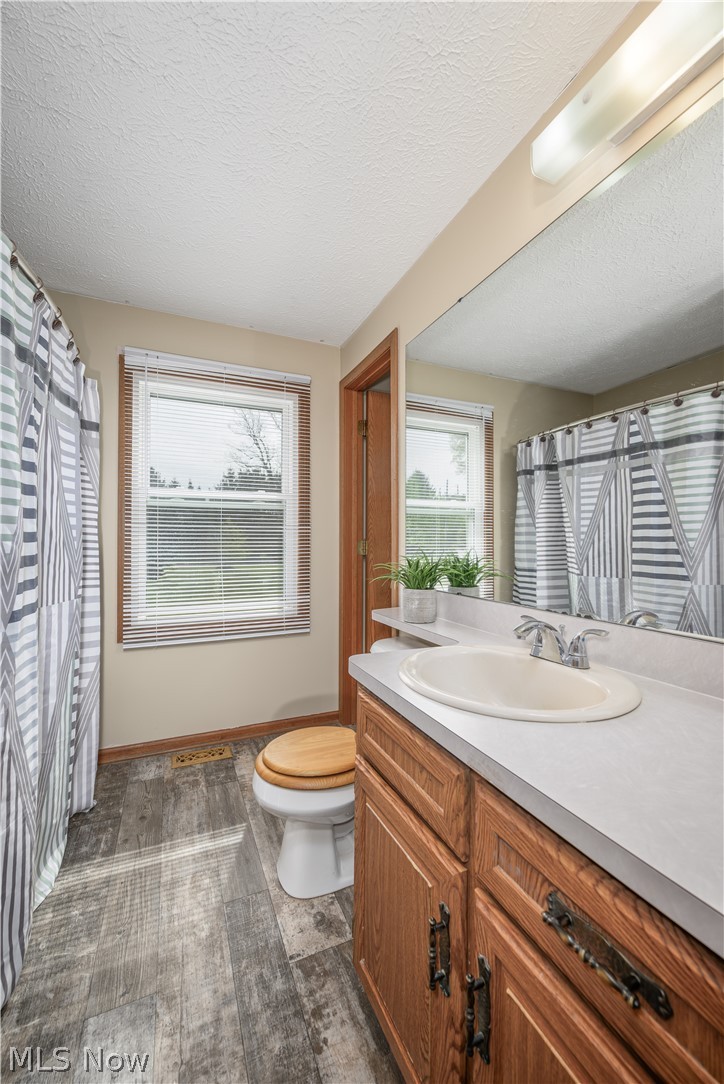 4715 Rock Spring Road Ravenna, OH 44266 - Photo 16 of 21 Bathroom featuring a wood-finish vanity with a light-toned countertop and integrated sink