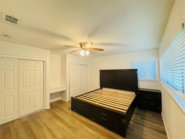 a bedroom with a bed and a ceiling fan