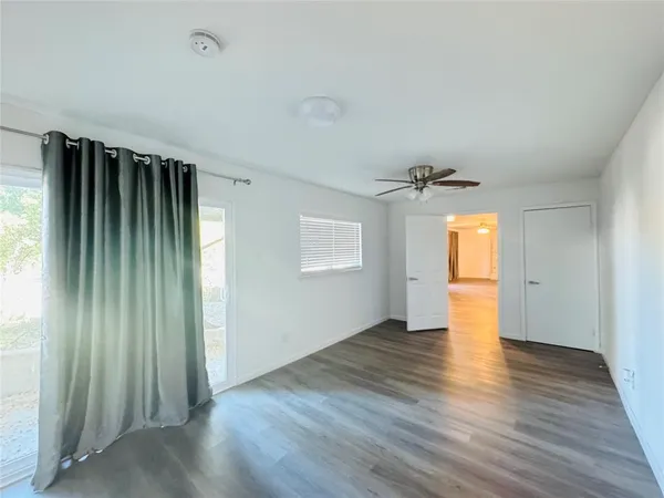 an empty room with wooden floor and windows