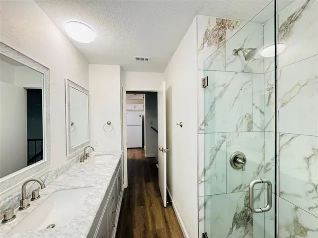 a bathroom with a granite countertop shower sink and mirror