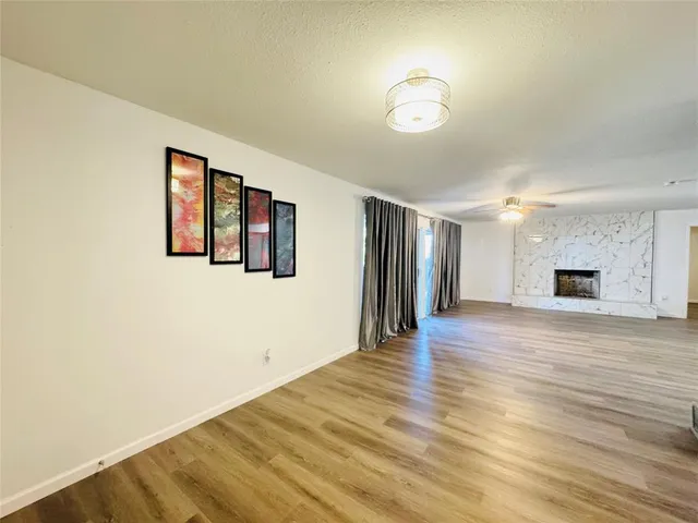 a view of a livingroom with wooden floor and a ceiling fan