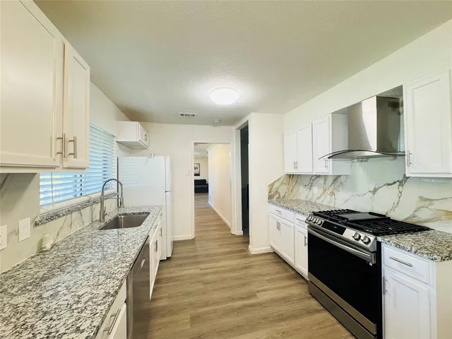 a kitchen with stainless steel appliances granite countertop a stove and a sink