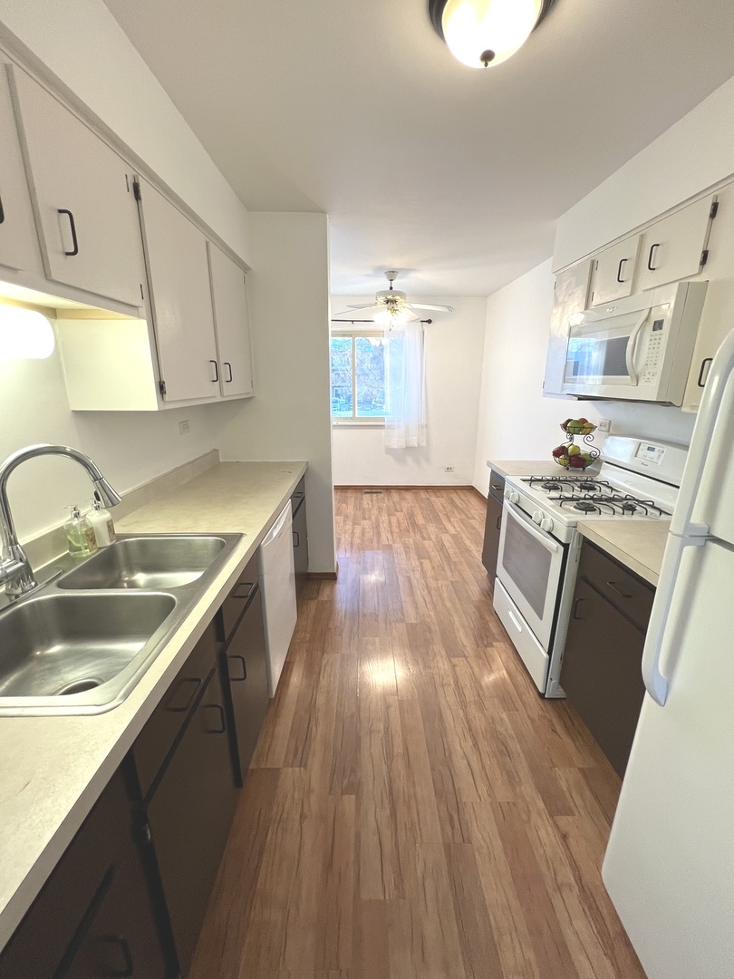 1706 Lakeview Drive Wheeling, IL 60090 - Photo 6 of 14 a kitchen with stainless steel appliances granite countertop a sink stove and wooden floor