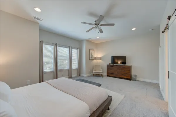 a bedroom with a bed a television and a window