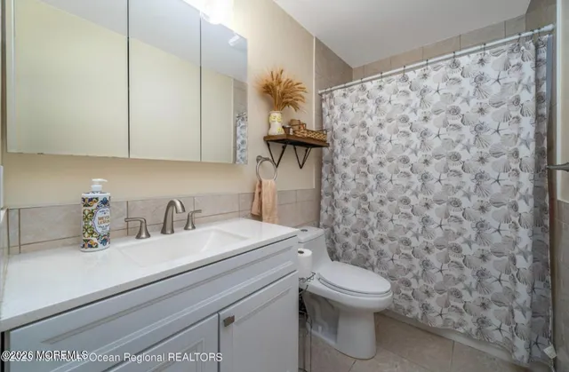 a bathroom with a granite countertop sink a toilet and a mirror