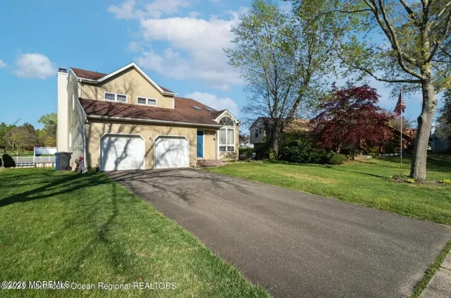 a front view of a house with yard and green space