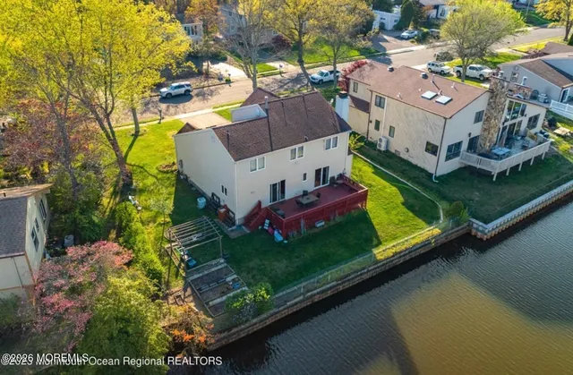 an aerial view of a house with a garden and lake view
