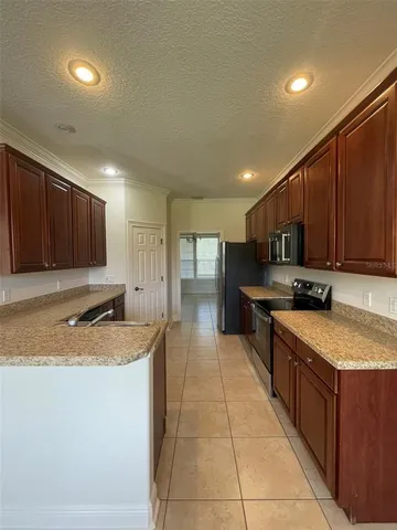 a kitchen with stainless steel appliances granite countertop a sink counter space cabinets and a large window
