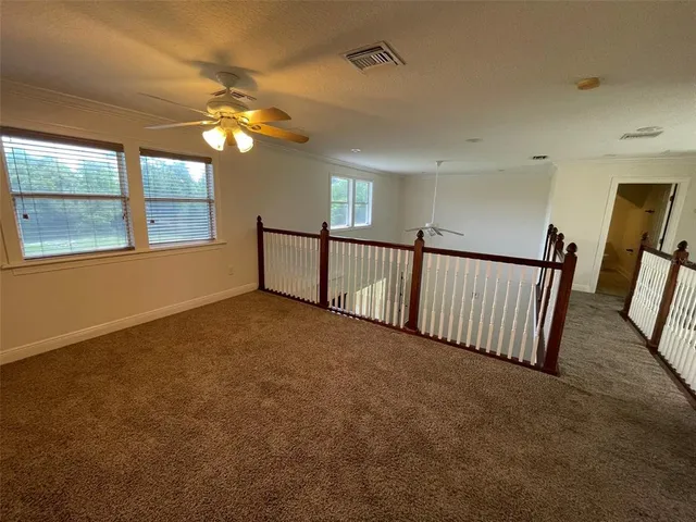 a view of empty room with stairs and chandelier fan