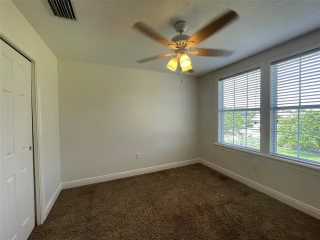 an empty room with a window and a fan