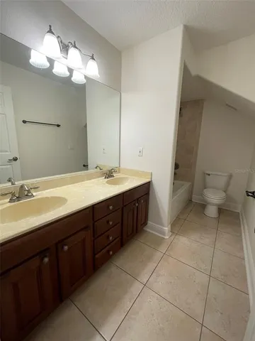 a spacious bathroom with a double vanity sink mirror and toilet