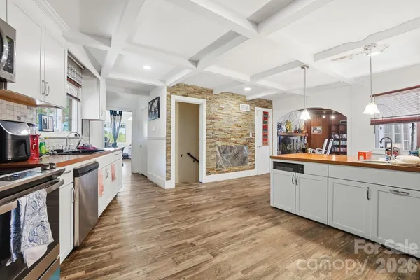 a large kitchen with a lot of counter space and wooden floor