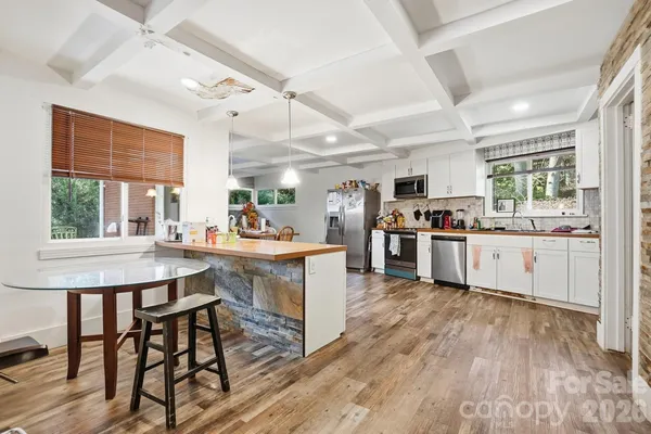 a kitchen with a table chairs refrigerator a sink dishwasher a dining table and chairs with wooden floor