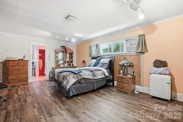 a bedroom with a bed and wooden floor