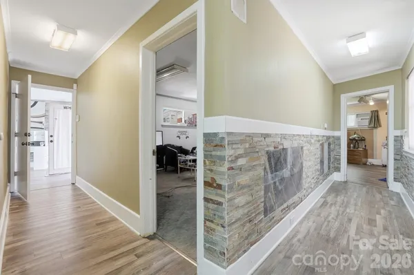 a view of a hallway with wooden floor and a living room