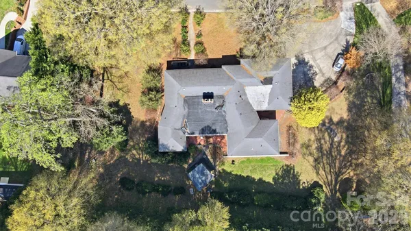 an aerial view of a house with a yard and large trees