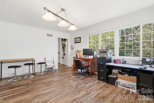 a view of a workspace with furniture and a window