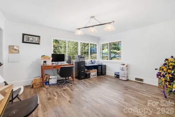 a view of a workspace with furniture and a window