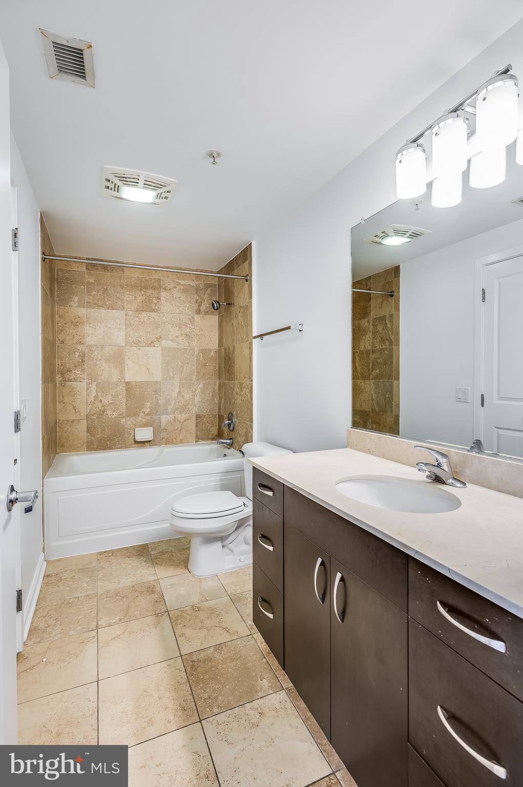 440 L Street Northwest, Unit 913 Washington, DC 20001 - Photo 22 of 42 a spacious bathroom with a granite countertop sink a toilet a mirror and bathtub