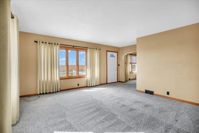 an empty room with a bathroom and a chandelier