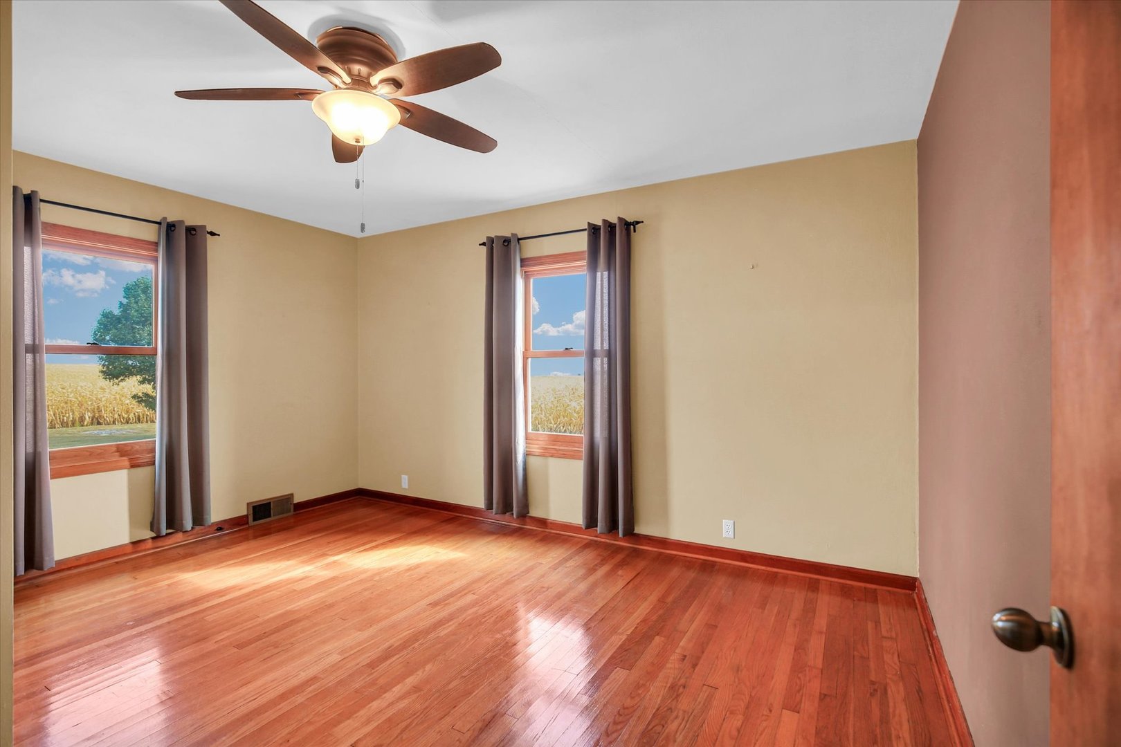 2151 East 2600 North Road Armstrong, IL 61812 - Photo 23 of 56 an empty room with wooden floor chandelier fan and windows