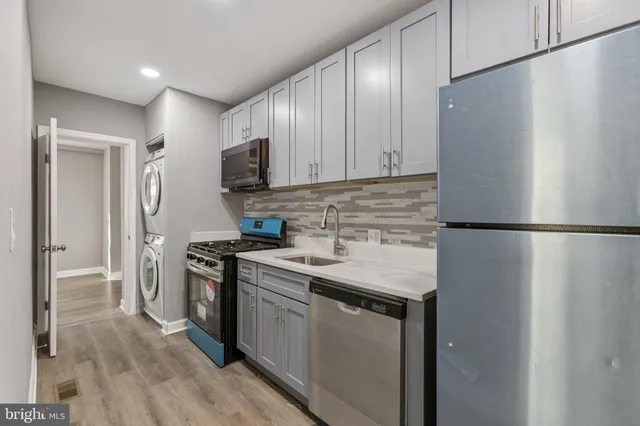 a kitchen with stainless steel appliances granite countertop a refrigerator a stove and a sink