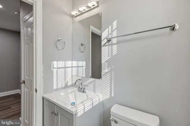 a bathroom with a granite countertop sink a toilet and a mirror
