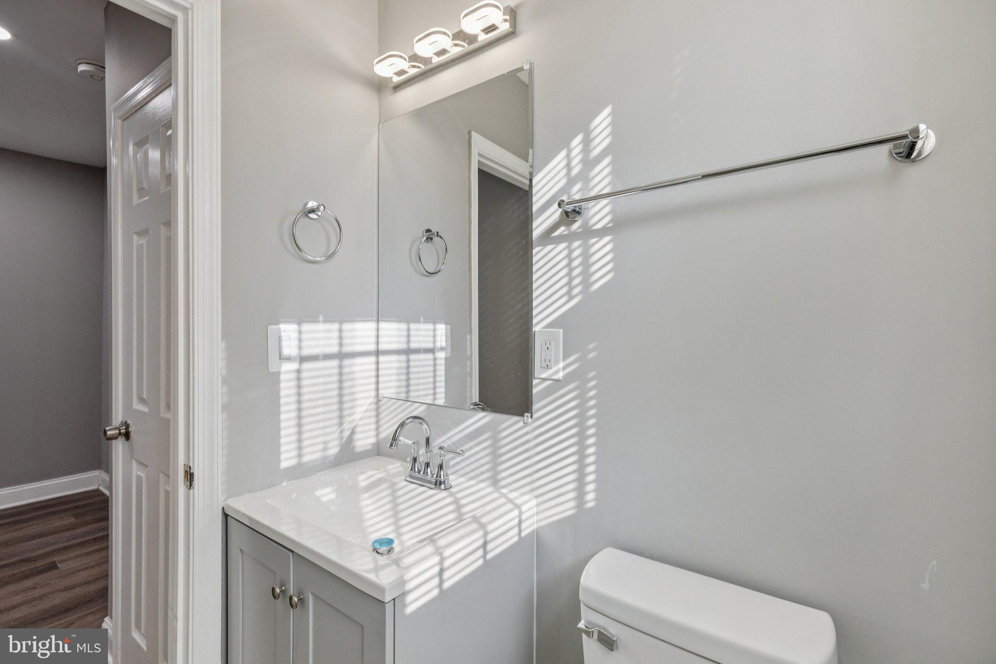 405 34th Street Southeast, Unit 1 Washington, DC 20019 - Photo 15 of 17 a bathroom with a granite countertop sink a toilet and a mirror