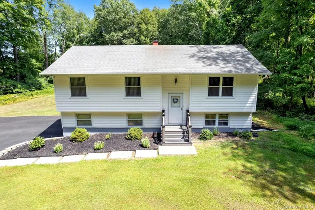 a view of a house with pool and chairs