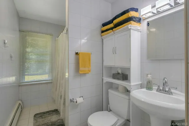 a bathroom with a sink toilet and mirror