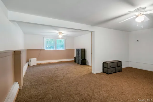a view of empty room with furniture and a window