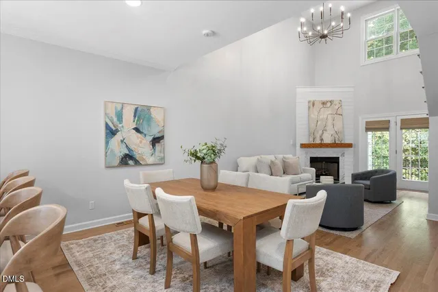 a dining room with furniture a rug a fireplace and a chandelier