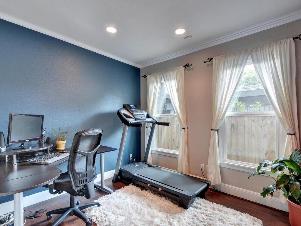 610 West N Loop Boulevard Austin, TX 78751 - Photo 17 of 29 The room features a blue accent wall, recessed lighting, and hardwood floors