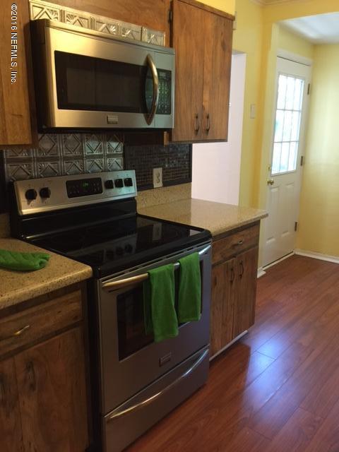 4773 Myrtlewood Road Jacksonville, FL 32210 - Photo 6 of 12 a kitchen with stainless steel appliances a stove a microwave a sink and cabinets