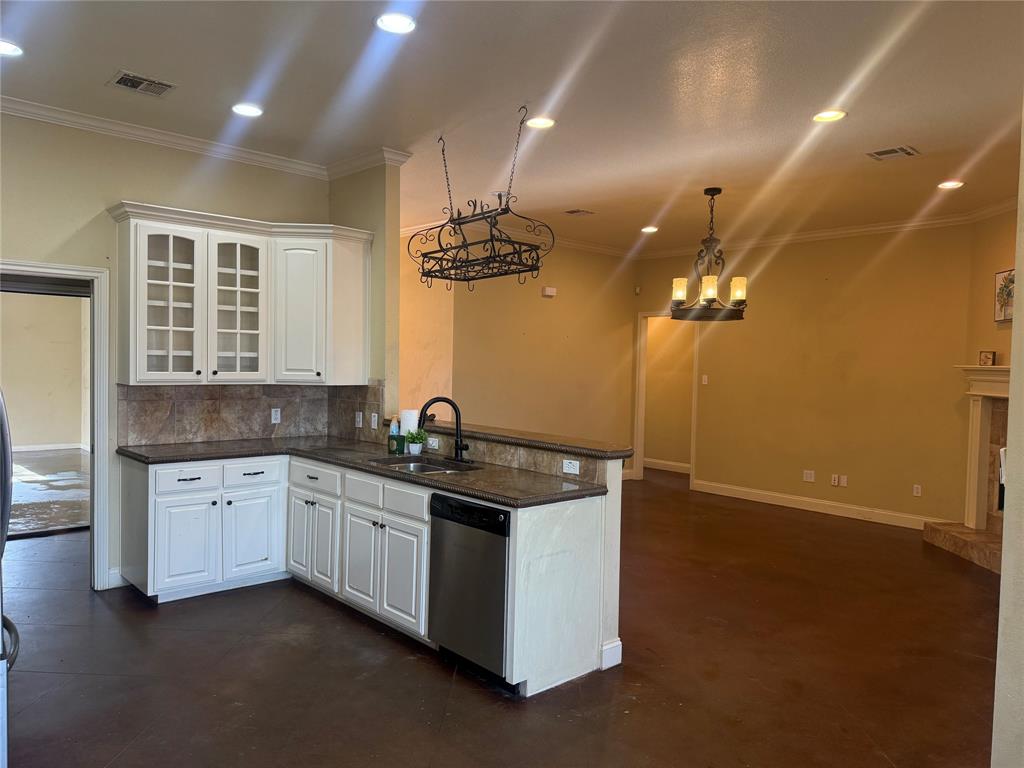 2524 Riders Way Woodway, TX 76712 - Photo 2 of 35 Kitchen featuring crown molding, white cabinetry, glass insert cabinets, stainless steel dishwasher, and concrete floors