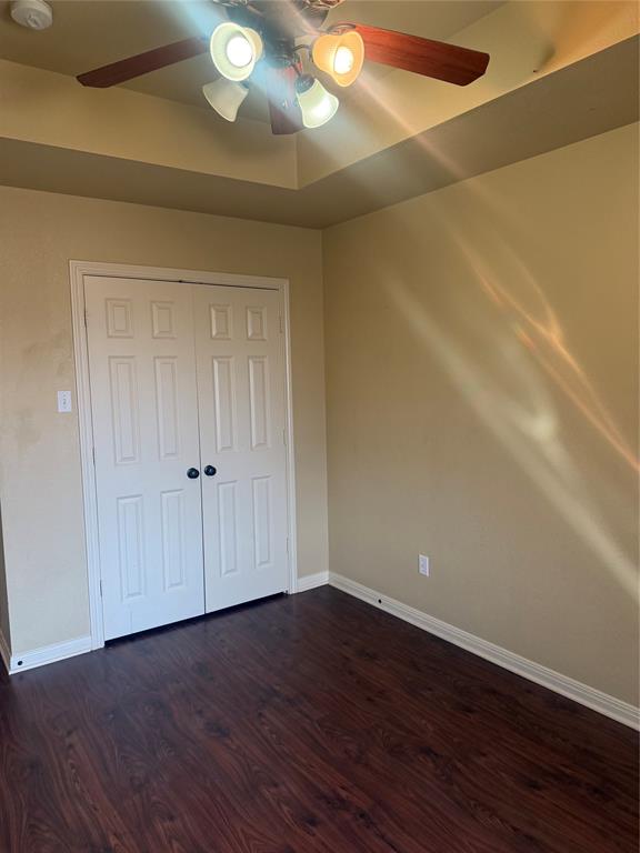 2524 Riders Way Woodway, TX 76712 - Photo 25 of 35 Unfurnished bedroom featuring dark wood-style floors, a ceiling fan, and a closet