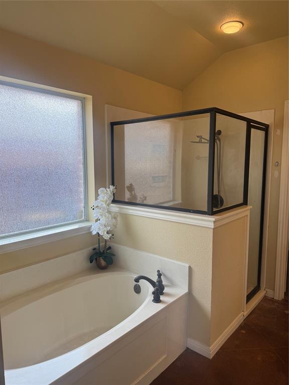 2524 Riders Way Woodway, TX 76712 - Photo 9 of 35 Bathroom with a shower stall, a garden tub, lofted ceiling, and dark tile patterned flooring