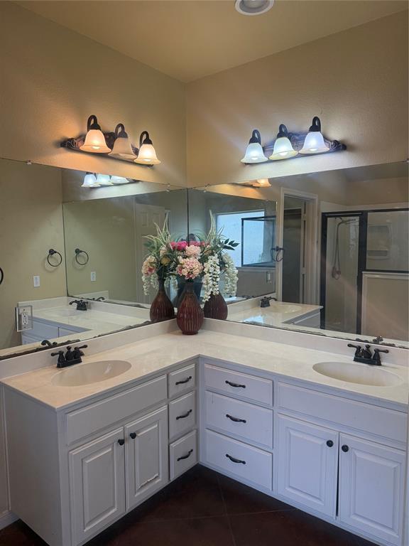 2524 Riders Way Woodway, TX 76712 - Photo 10 of 35 Full bath with double vanity, dark tile patterned floors, and a stall shower