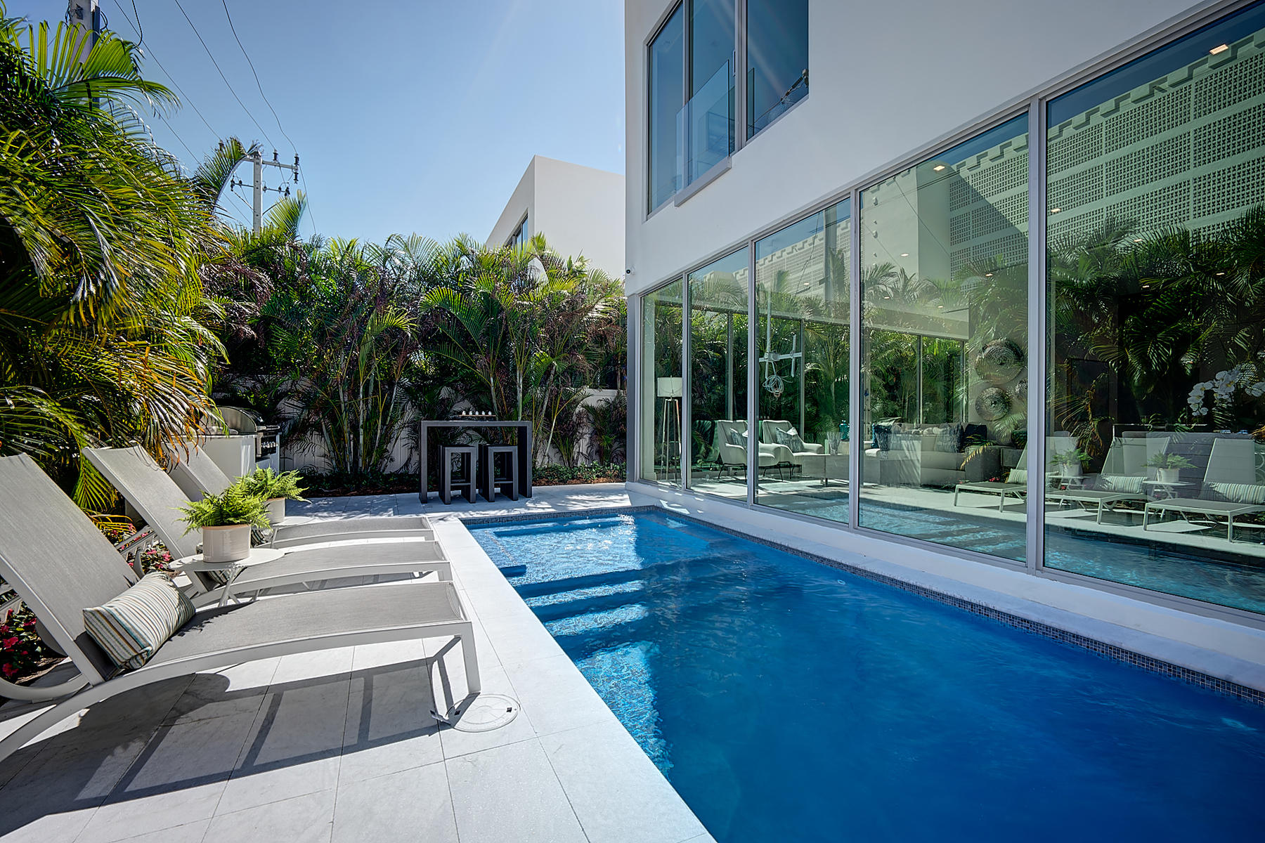 3092 Banyan Road, Unit A Boca Raton, FL 33432 - Photo 23 of 49 a view of a patio with table and chairs potted plants and floor to ceiling window