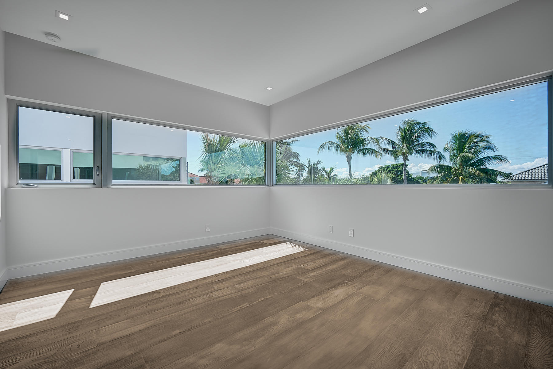 3092 Banyan Road, Unit A Boca Raton, FL 33432 - Photo 27 of 49 an empty room with wooden floor and windows