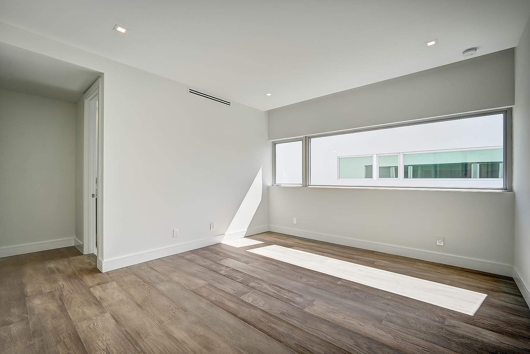 3092 Banyan Road, Unit A Boca Raton, FL 33432 - Photo 30 of 49 an empty room with wooden floor and windows