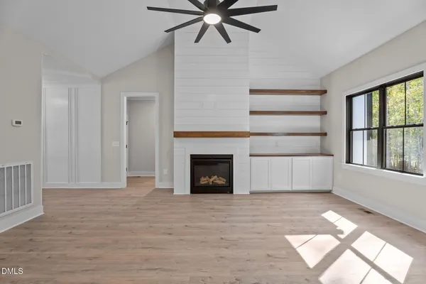 a view of a livingroom with a fireplace and window