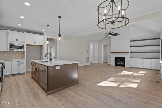 a kitchen with stainless steel appliances granite countertop a sink a stove and a wooden floors