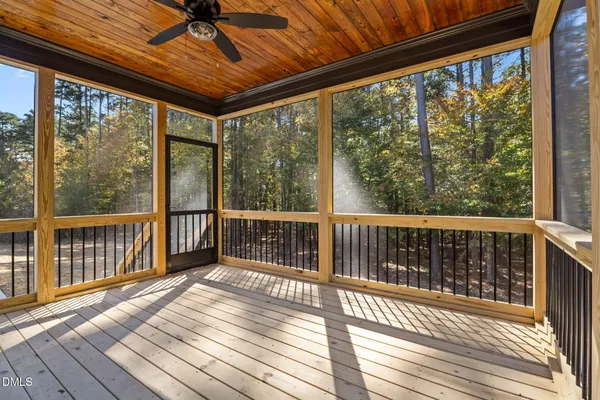 a view of a house with wooden deck and furniture